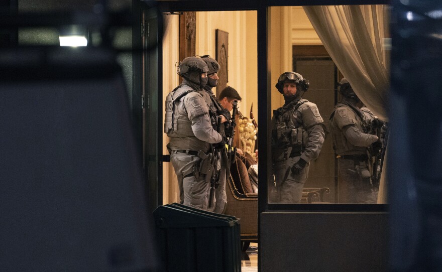 York Regional Police tactical officers stand in the lobby of a condominium building in Vaughan, Ontario, Sunday, Dec. 18, 2022. Police said multiple people are dead, including the suspect, after a shooting in a unit of the building.