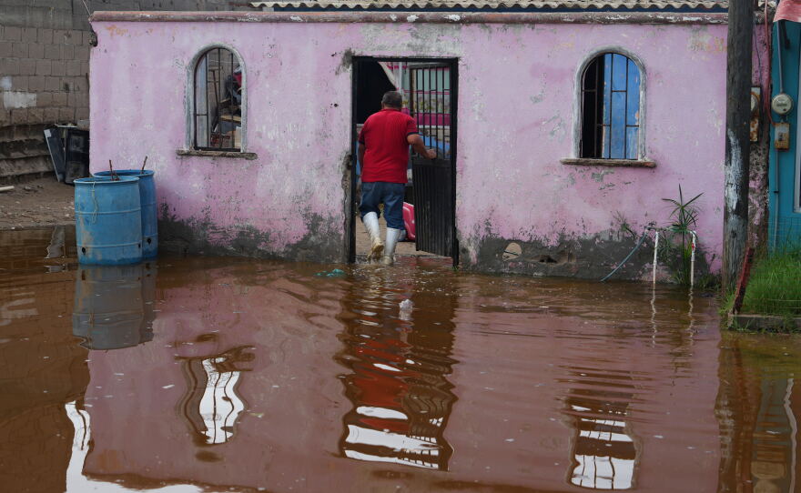 A resident enters his home surrounded by water brought by Hurricane Polo in Puerto San Carlos, Baja California Sur state, Mexico, Tuesday, Sept. 29, 2026. (AP Photo/Eduardo Verdugo)