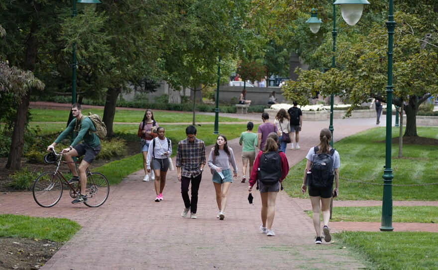 Students walk to and from classes on the Indiana University campus in Bloomington, Ind., in 2021.
