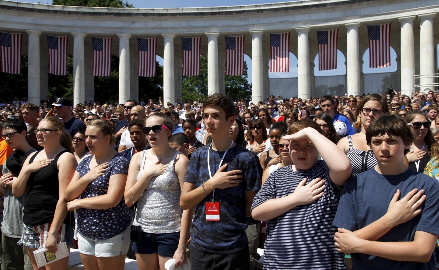 Crowds stand for the national anthem during the Memorial Day observance at Arlington National Cemetery.
