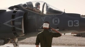 Lance Cpl. Harrison York, a AV-8B Harrier II Plus maintainer with Marine Attack Squadron 211, 3rd Marine Aircraft Wing (Forward), salutes Capt. Stephen White, a Harrier pilot, as he taxis in to the Camp Bastion, Afghanistan, flightline, Sept. 26., 2012.