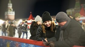 Visitors enjoy the ice rink in Red Square at the Moscow GUM State Department store with the Spasskaya Tower to the left and the Kremlin Wall in Moscow on Monday.