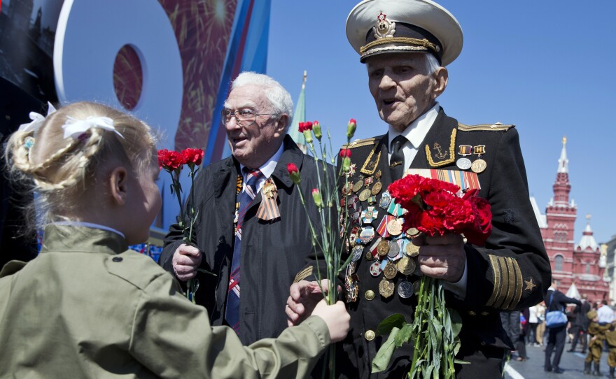 A girl gives flowers to World War II veteran Ivan Bobarykin after Friday's Victory Day parade in Red Square in Moscow. Thousands of Russian troops marched in the annual parade.