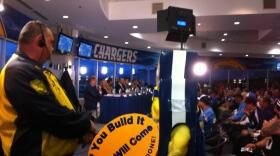 Hundreds pack into a club lounge at Qualcomm Stadium to urge Mayor Kevin Faulconer's Citizens Stadium Advisory Group to get a deal done for the San Diego Chargers to have a new stadium. Unofficial mascot Boltman holds a sign with that message, March 2, 2015.