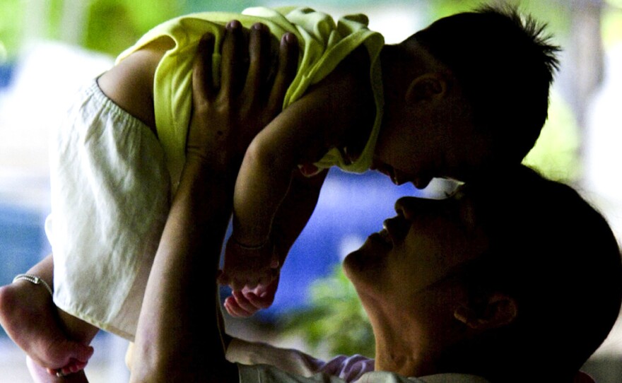 An HIV-positive mother in Thailand plays with her son, who did not contract the virus in utero. Thailand has eliminated mother-to-child transmission of HIV, according to the World Health Organization.