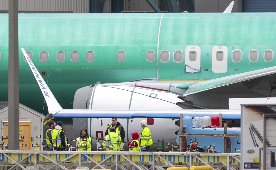 Workers are pictured next to an unpainted 737 aircraft and unattached wing with the Ryanair logo as Boeing's 737 factory teams held a "Quality Stand Down" for the 737 program at Boeing's factory in Renton, Wash. on January 25, 2024.