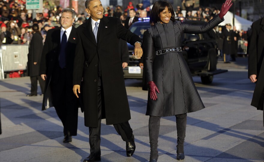 President Obama and first lady Michelle Obama walk in the inauguration parade near the White House. The first lady chose a jacket by designer Thom Browne.