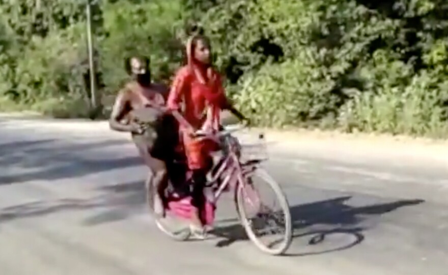 In this screen grab from video posted by BBC News Hindi, 15-year-old Jyoti Kumari rides with her father during their 700 mile-long journey to their family's village of Sirhulli in eastern India.
