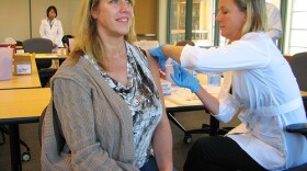 A nurse gives a woman a flu shot. 