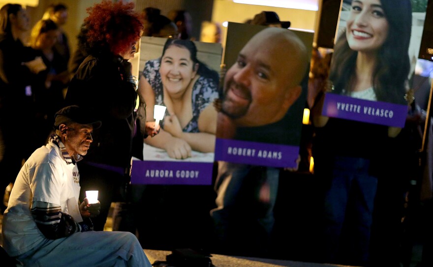 Photographs of victims of the terrorist attack on the Inland Regional Center are seen as people hold candles while attending a vigil held at the San Bernardino County Board of Supervisors headquarters to remember those injured and killed during the shooting on December 7, 2015 in San Bernardino, Calif.