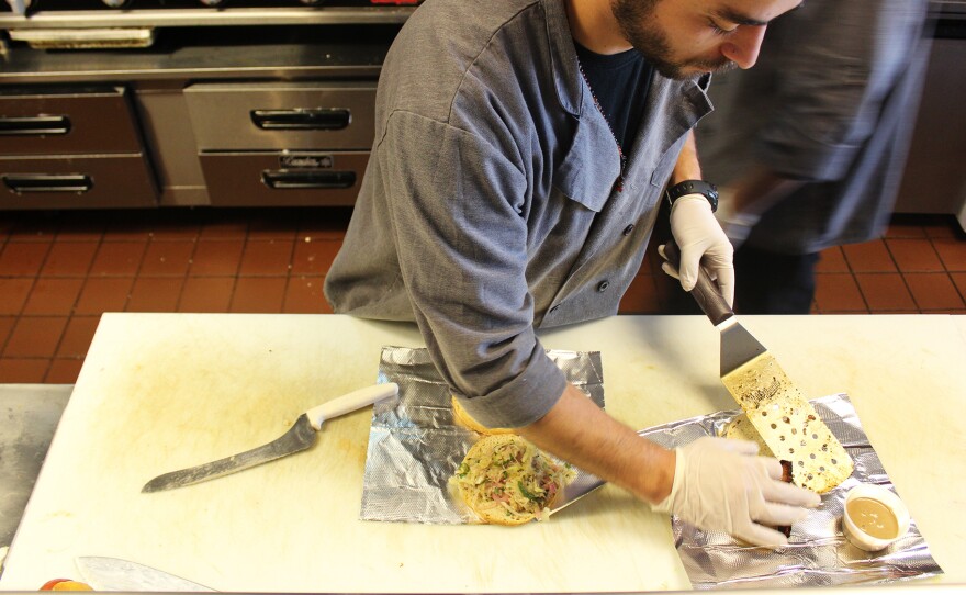 A worker at Moo Cluck Moo, a fast-casual burger and chicken chain in suburban Detroit, prepares a meal. Workers at Moo Cluck Moo all make $15 an hour.