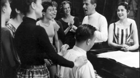 Leonard Bernstein at rehearsal for West Side Story. Carol Lawrence (who played Maria) is at his left, and lyricist Stephen Sondheim is playing the piano, 1957.