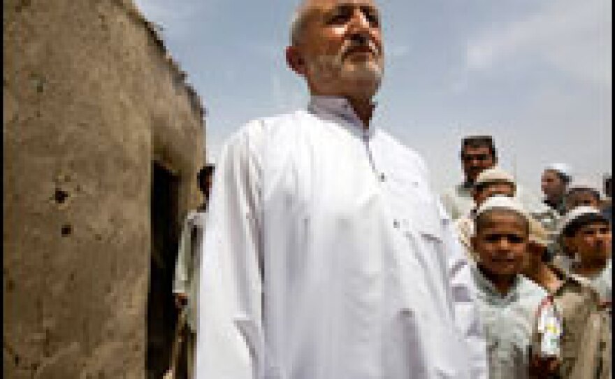 Derwayza Achakzai stands where his wife, Kandahar provincial council member and women's rights activist Sitara Achakzai, was shot and killed outside their home in Kandahar, Afghanistan. Achakzai was returning home on April 12 when four men on two motorcycles drove up and shot her. Bullet holes still mark the outside wall of the building.