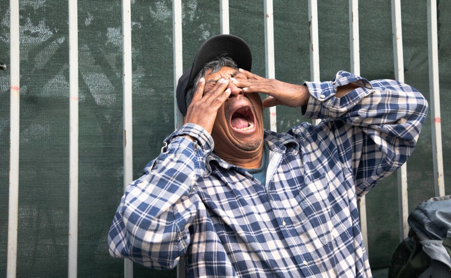 A man who didn’t want to give his name yawns in the early morning while sitting on 16th Street in San Diego, May 20, 2020.