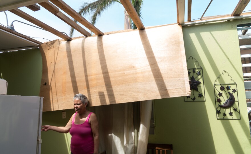 Maria Reyes, 63, stands in her home, which was severely damaged by the storm. She spends most of her time these days caring for her 82-year-old mother, Rafaela.