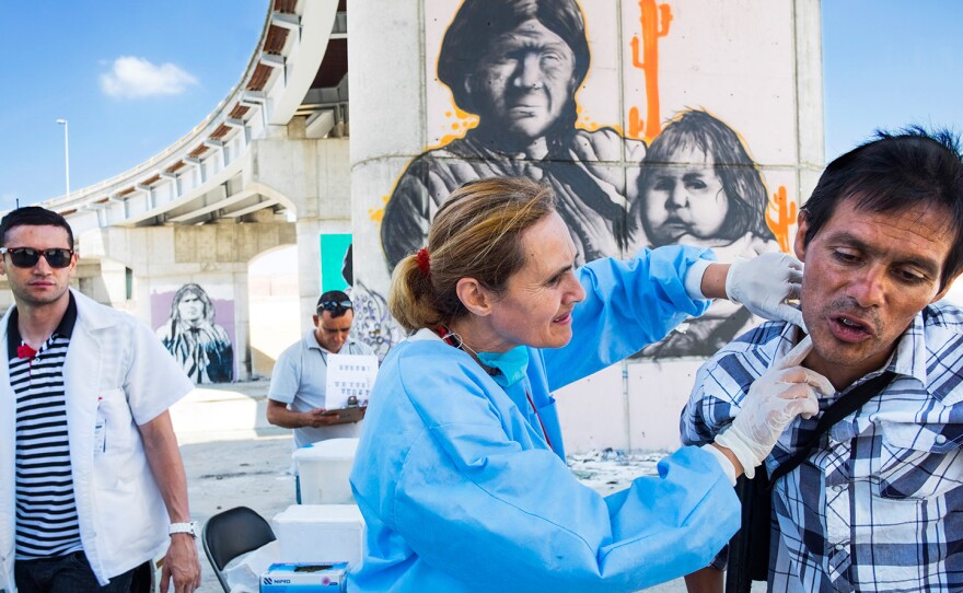 Dr. Patricia Gonzalez examines a patient's neck at a first-aid clinic that she started in 2014 in the Tijuana River Canal, where hundreds of drug users live. Some of them inject in the neck; wounds can result.