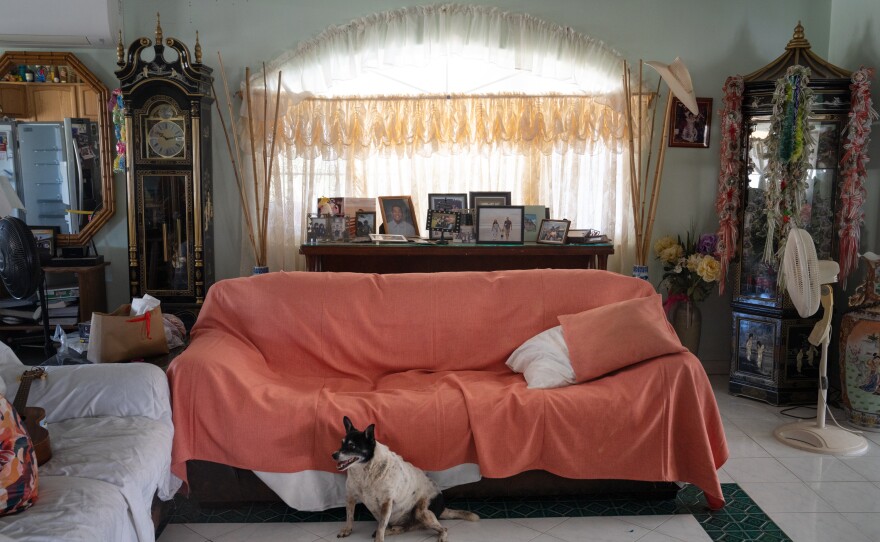 Princess is one of the three family dogs. He follows Andres to the living room. Family photos can be seen all over the house.