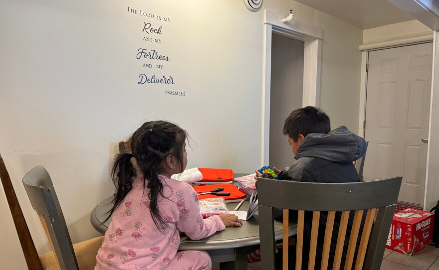 Two children draw in coloring books in a safe house in Minneapolis on Friday, Jan. 16, 2026. Their mother and grandmother were detained earlier that month by federal immigration agents.