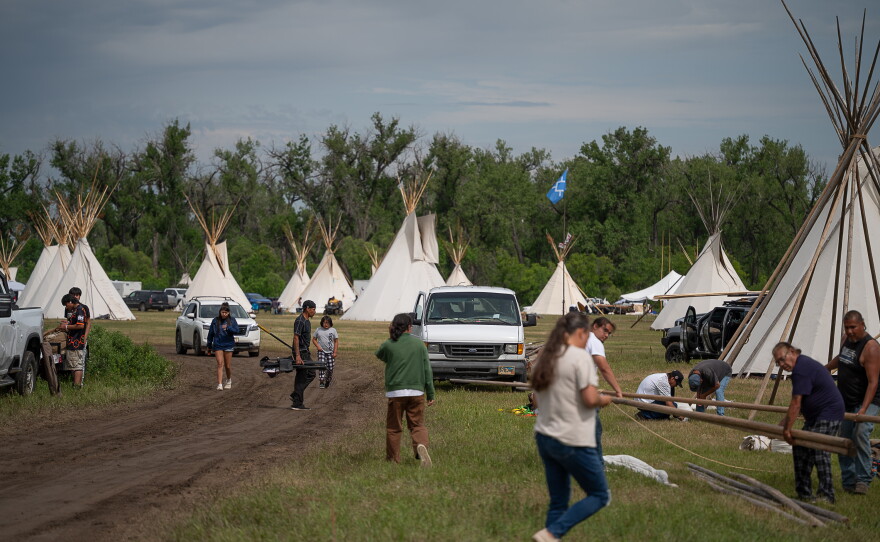 People are taking down tipis at an encampment along the Little Bighorn River during the 150th anniversary commemoration of the Battle of the Little Bighorn near Little Bighorn Battlefield National Monument. The encampment brought together tribal members from across the Plains for ceremonies, storytelling and remembrance.