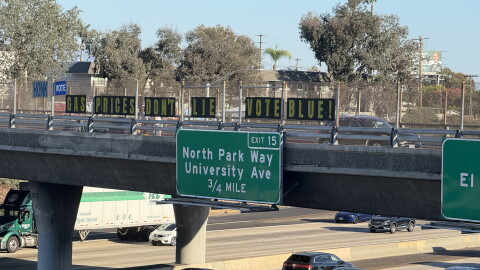 Letters spelling out the phrase, "Gas prices don't lie. Vote blue," are displayed on the Meade Avenue bridge over Interstate 805 on Oct. 8, 2026.