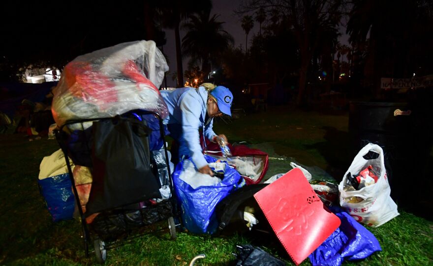 A woman packs her belongings on March 24, 2021, before police begin clearing out the encampment at Echo Park Lake.