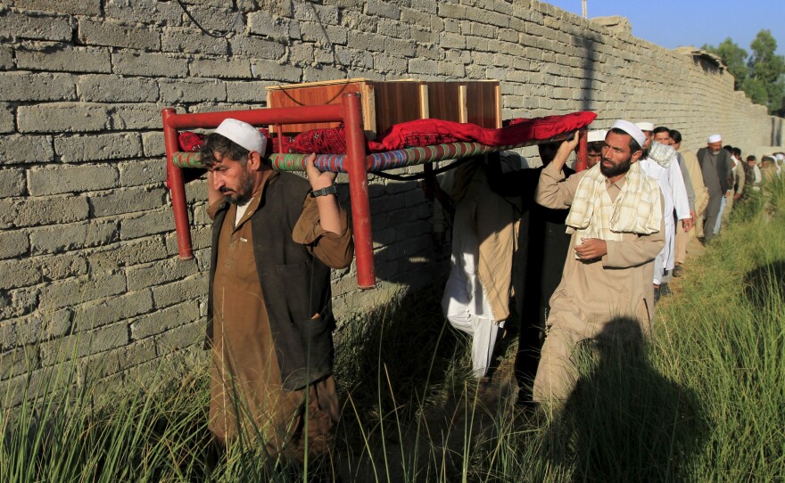 Afghan men carry a coffin of an earthquake victim for burial in the Behsud district of Nangarhar province, Afghanistan, on Tuesday.