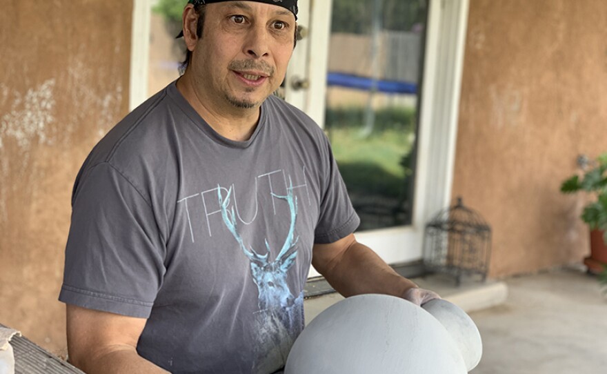 Diego Romero sanding a vessel.