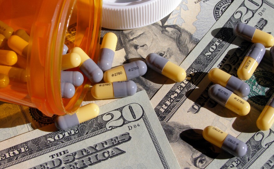This undated photo shows prescription pills atop $20 bills.