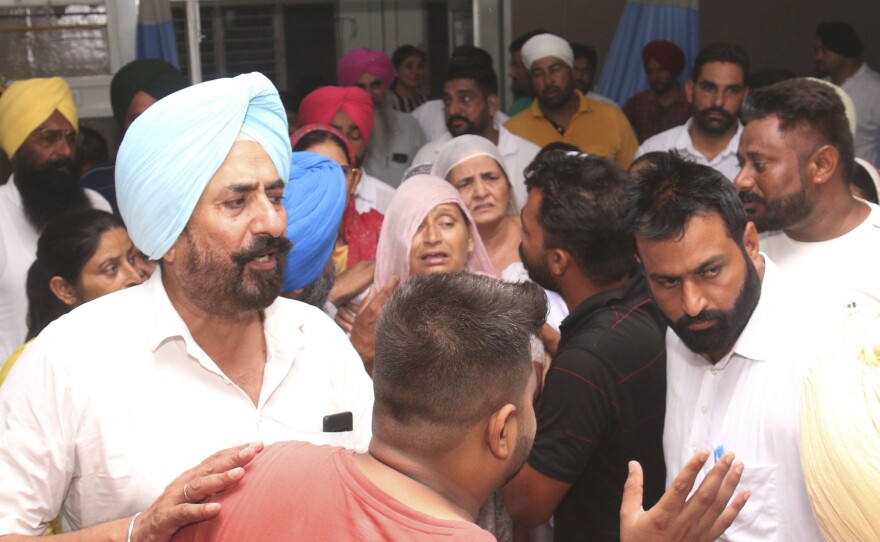 Relatives and friends of Shubhdeep Singh Sidhu, also known around the world by his stage name Sidhu Moose Wala, arrive at a hospital after he was shot in Mansa, India on Sunday.