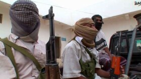 An Al Qaeda police force on the back of a pickup truck prepares to go on patrol in town of Azzan, Yemen.