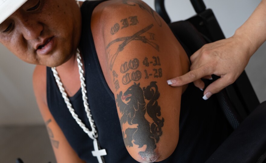 Alicia Lammers points to her husband, Matt's infantry tattoo on his left shoulder.