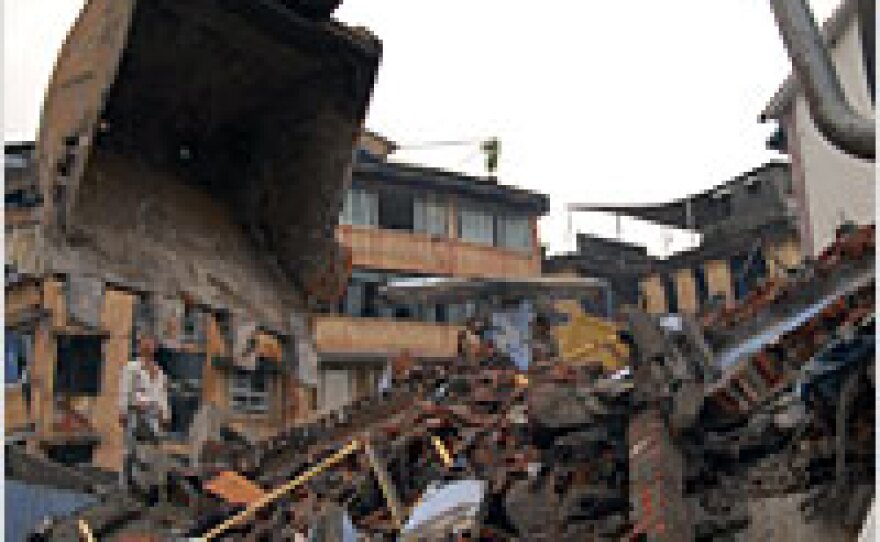Wang Wei stands atop the rubble of his family's apartment building in Dujiangyan, China.
