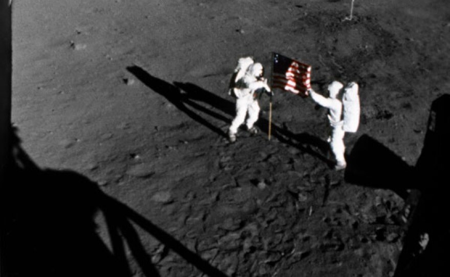 Neil Armstrong and Buzz Aldrin on the surface of the moon, with the American flag. 21 July 1969.