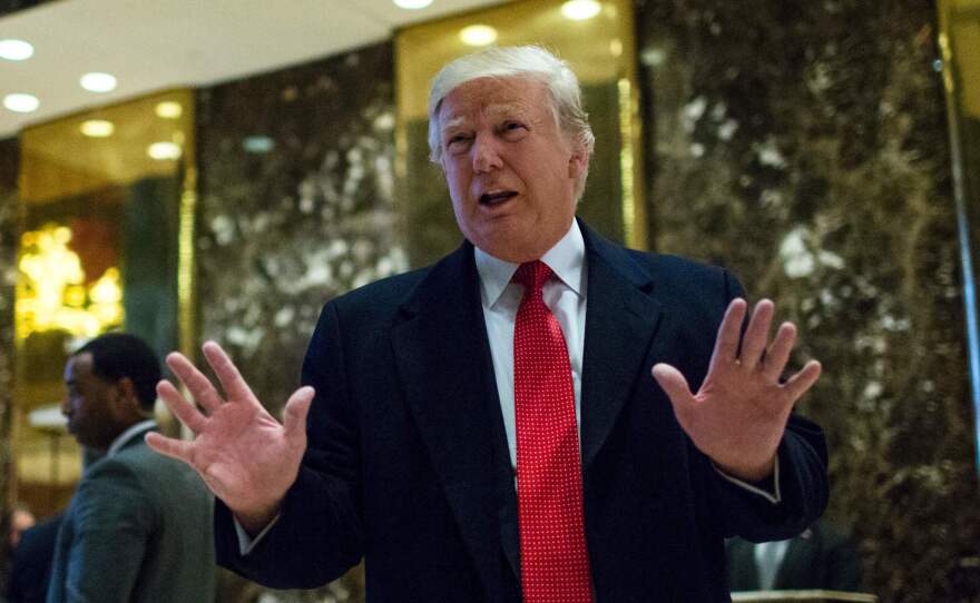 President-elect Donald Trump speaks with the media at Trump Tower in New York on Dec. 6, 2016. Ethics experts warn that Trump's business interests could violate the Constitution.