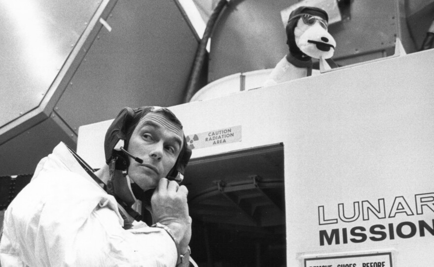 Gene Cernan prepares for his 1969 Apollo 10 flight, adjusting his headset outside a lunar module simulator.