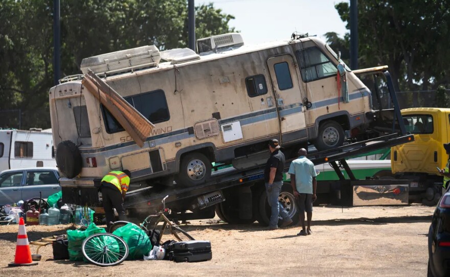 Wayne Gardiner, 58, right, watches as a tow truck removes the RV he has owned for more than 20 years during a sweep at Columbus Park, the city’s largest homeless encampment, in San Jose on Aug. 25, 2025. The city offered Columbus Park residents $2,000 for their RVs. “The facts of life is that things like this will happen. You have to take the deal because they’re gonna take it anyways,” he said. “I have to just let it go.”