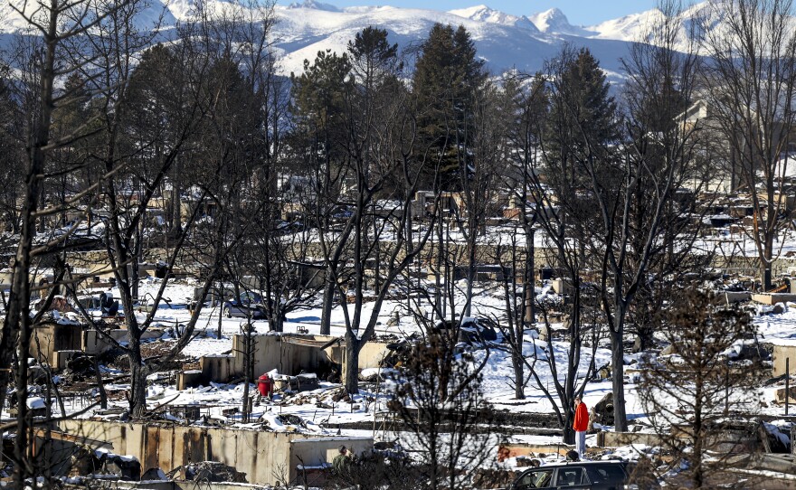 A woman looks at the remains of a home in a neighborhood decimated by a fire on January 2, 2022 in Louisville, Colorado. Nearly a thousand homes were destroyed, making it the most destructive wildfire in Colorado history.