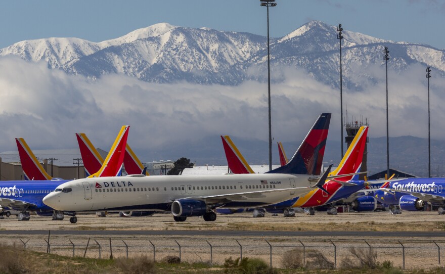 A Delta Air Lines jet taxis past Southwest Airlines jets to be parked with a growing number of jets at Southern California Logistics Airport on March 24, 2020 in Victorville, Calif. As the coronavirus pandemic grows, exponentially increasing travel restrictions and the numbers of people in quarantine, airlines around the world are scrambling to find places to park a majority of their fleet.