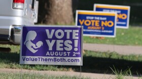 Political signs for the state constitutional amendment vote on abortion rights in Kansas sit near each other in yards in Overland Park, Kan., July 16, 2022.
