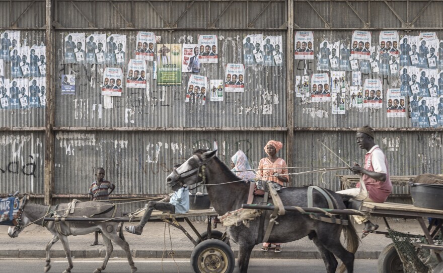 Carts ride past electoral posters in Dhara on March 21, 2024, as eighteen men and one woman are in the running on March 24 to become Senegal's fifth president.