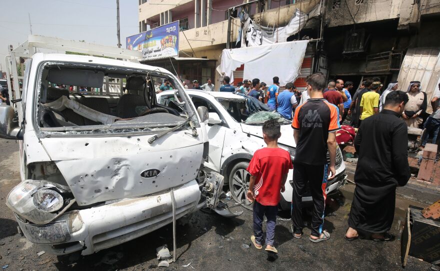 Iraqis look at the damage following a car bomb attack in Sadr City, a Shiite area north of the capital, Baghdad, on Wednesday.