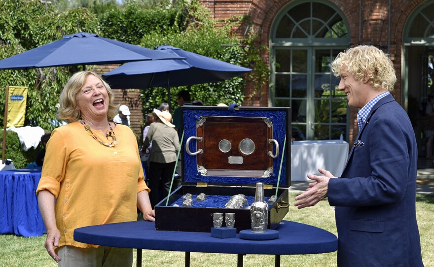 Jason Preston (right) appraises a 1908 Arthur & Bond presentation silver cocktail set, in Woodside, Calif. 