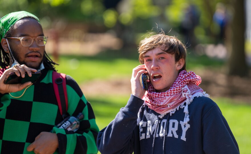 A protester talks on the phone after being exposed to pepper spray and tear gas on the campus of Emory University on Thursday, April 25, 2024.