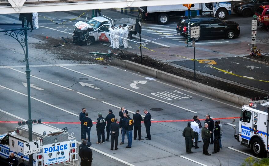 Investigators inspect a truck following a shooting incident in New York on Tuesday. Eight people were killed and at least 11 others injured in New York on Tuesday when a suspect plowed a vehicle into a bike and pedestrian path in Lower Manhattan, and struck another vehicle. A suspect exited the vehicle holding up fake guns, before being shot by police and taken into custody, officers said.