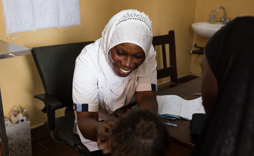 Nabia Drammeh, 27, a nurse, talks with Maram Ceesay, and her granddaughter, Awa at the Brufut Minor Health Center outside of Banjul, the Gambia. Awa's mother passed away during childbirth leaving her Maram to look after her. The 2-year-old is being treated for pneumonia.