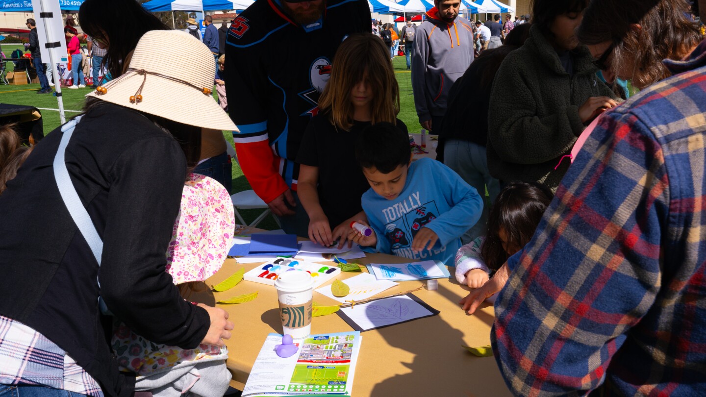 Families make art by rubbing leaves with Olivewood Gardens and Learning Center at Be My Neighbor Day across the street from the KPBS station on Saturday, April 6 in San Diego, CA.