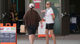A poll worker assists an Arizona voter at a polling location in Phoenix as people cast their ballots on Tuesday.