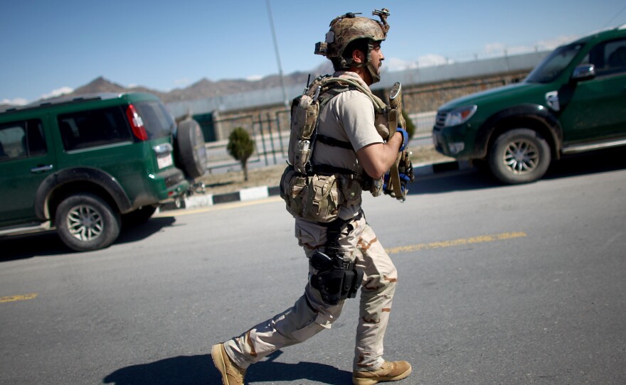 A soldier with the Afghan Special Forces approaches the main election office in Kabul following a Taliban attack. The Taliban have warned Afghans not to vote in the April 5 presidential poll.