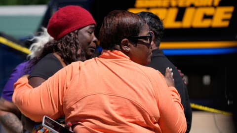 People console each other as they gather at the scene of a mass shooting in Shreveport, La., on Sunday.