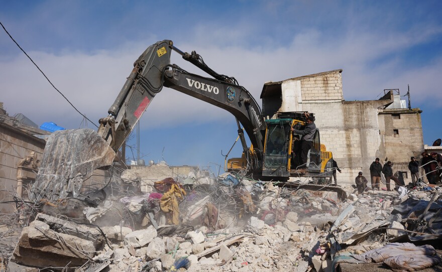People search the rubble of a house in which one entire family except a newborn baby was killed, in the town of Jandaris, in the rebel-held part of Aleppo province, Syria following a deadly earthquake on Tuesday.